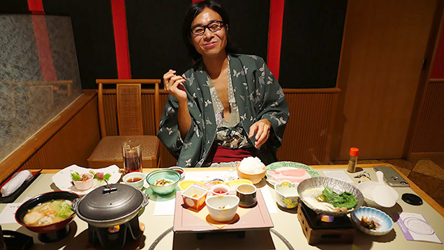 豪華な料理の前で笑顔の筆者