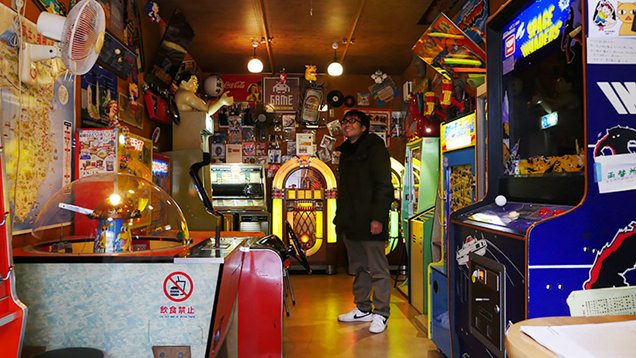 レトロなゲーム機に囲まれるライター地主恵亮