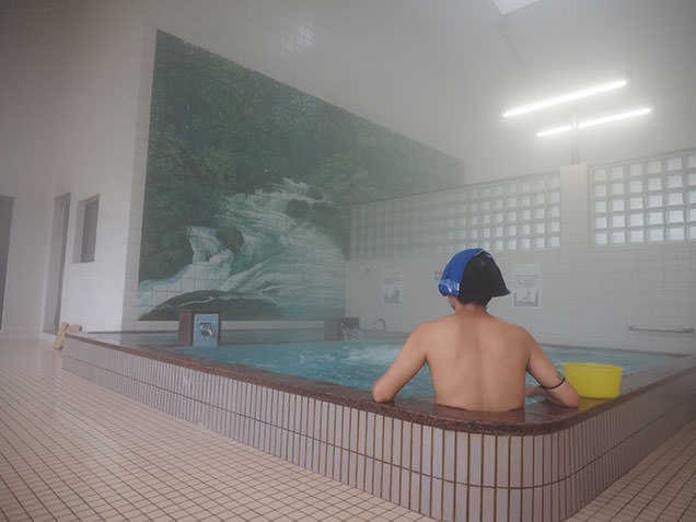 徳乃湯温泉で入浴し十和田湖の背景画を眺める毎川直也