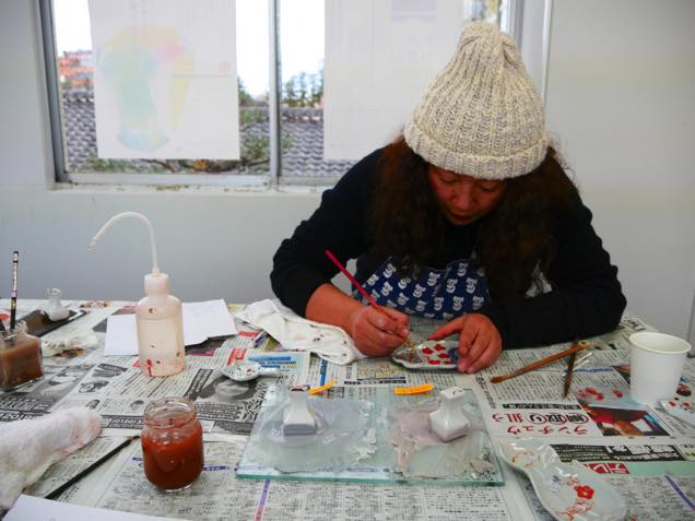 色絵豆皿に色付けする九谷焼作家の田辺京子さん