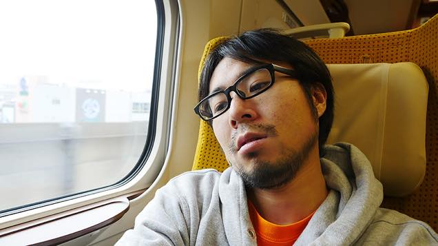 新幹線こまちの座席で疲れた表情を見せる筆者