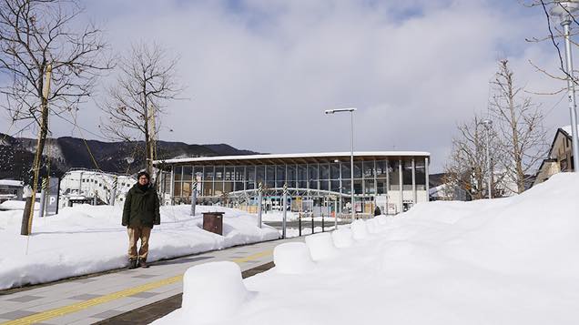 雪に囲まれた田沢湖駅前に立つ筆者