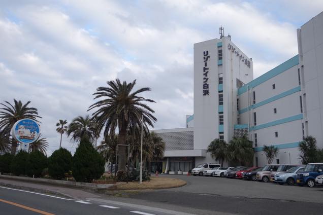 白い壁に水色のストライプが入ったホテルオーシャンズ白浜の外観