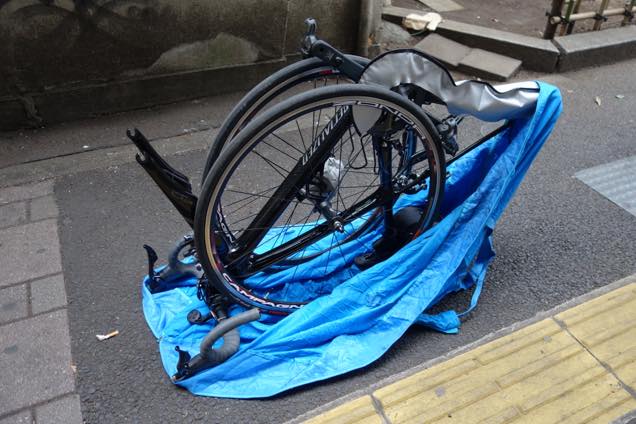 輪行袋にロードバイクを収める様子