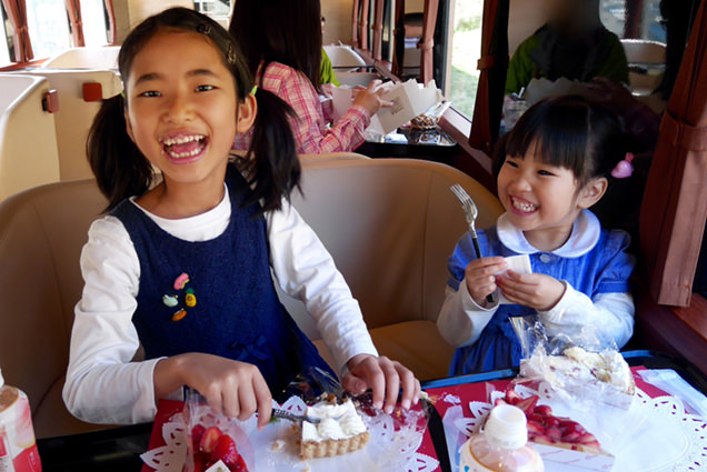 いちごのケーキを食べて満面の笑みを浮かべる姉妹