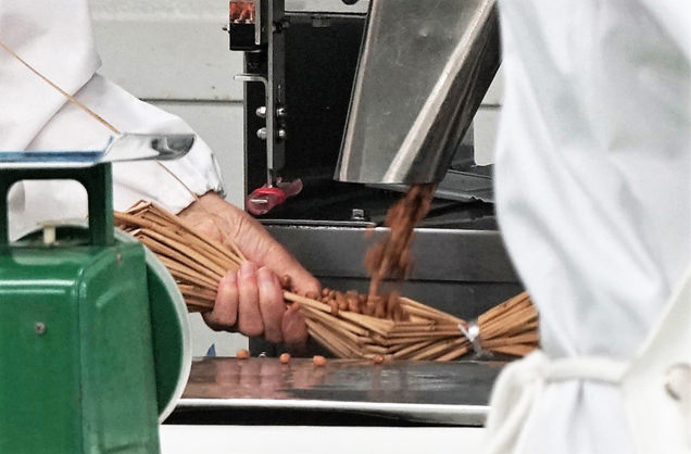 藁に煮豆が詰められる瞬間