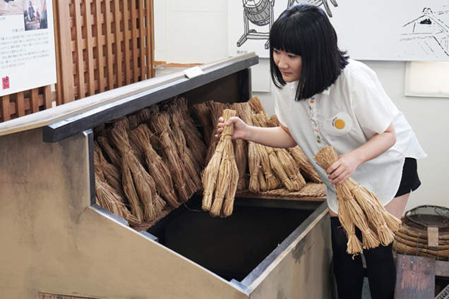 納豆室で藁を持つ朝井さん