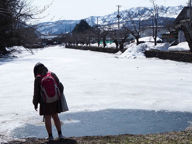 米沢城址の凍ったお堀の前に立つ娘