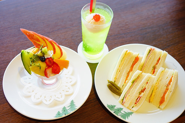 カフェのサンドウィッチとフルーツパフェとクリームソーダ