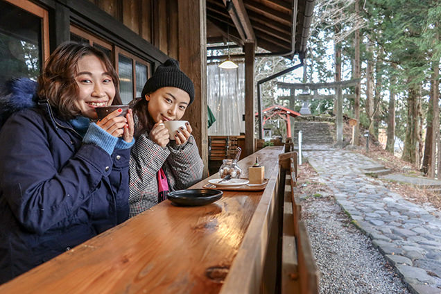 カフェのテラス席に座る筆者と友人