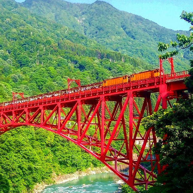 赤い橋を渡るトロッコ電車