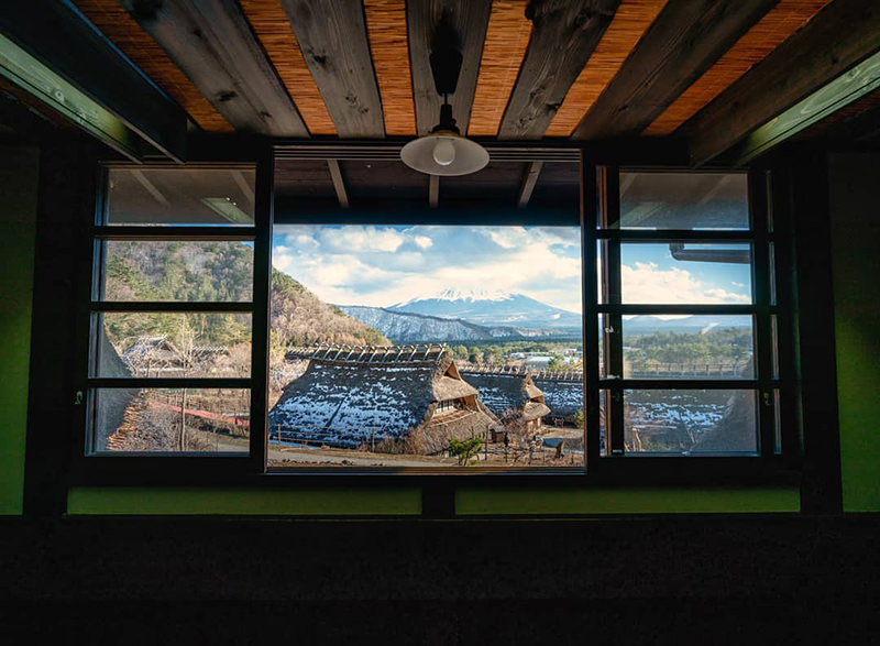 茅葺き屋根の家屋内からの富士山